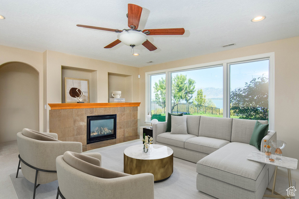 Living room featuring ceiling fan and a fireplace