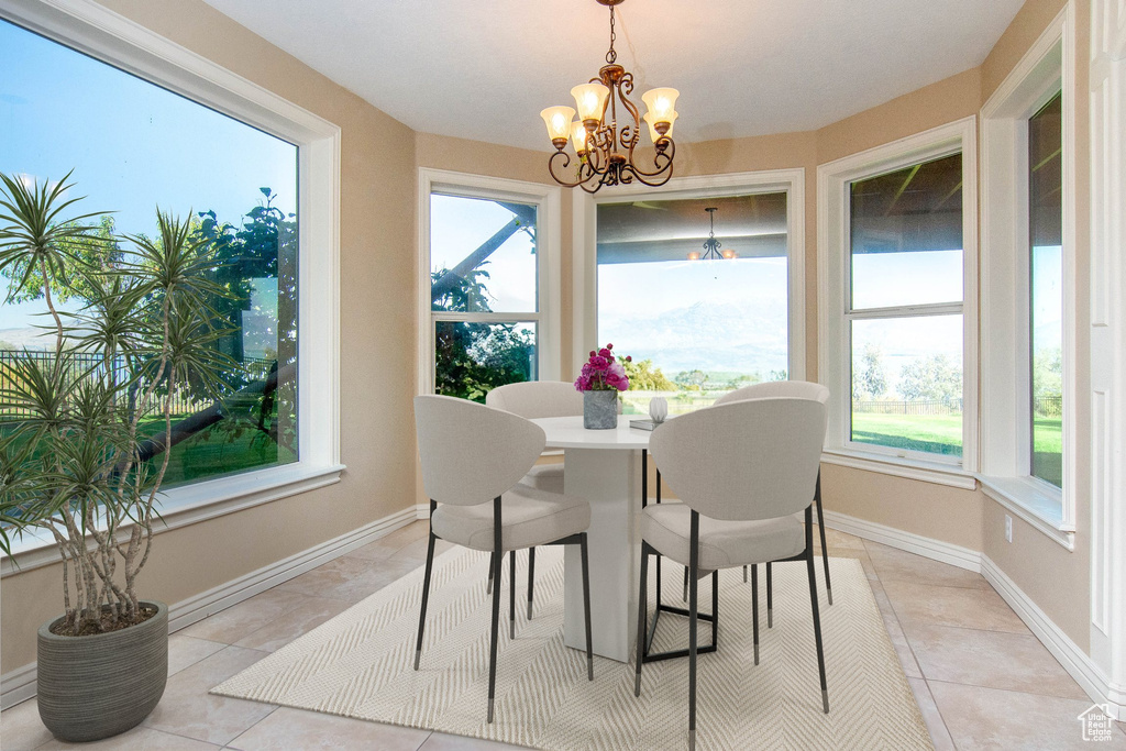 Tiled dining space with an inviting chandelier and plenty of natural light