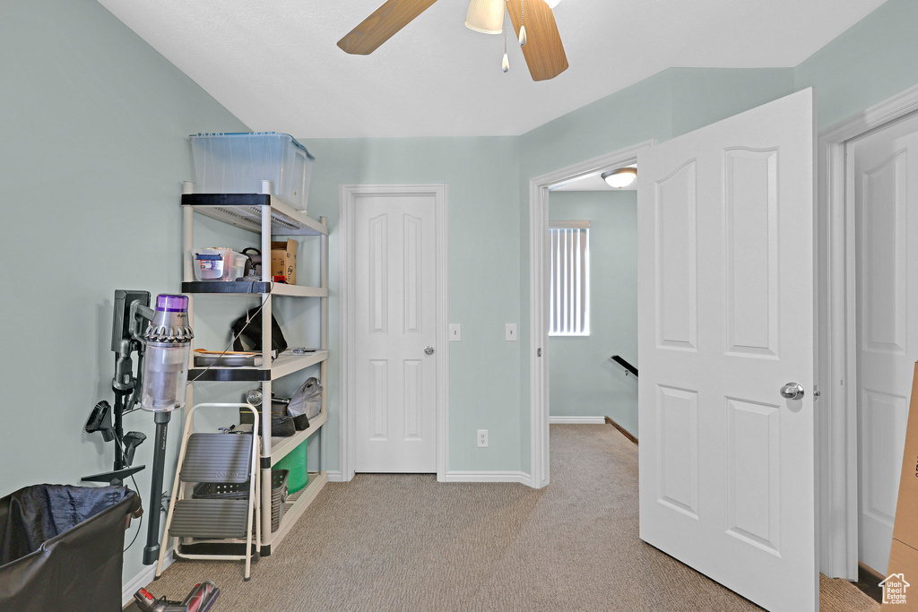 Interior space with ceiling fan and light colored carpet