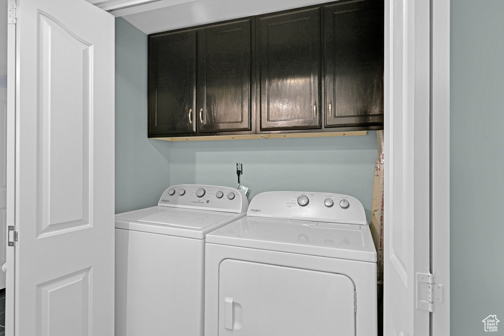 Washroom featuring cabinets and washer and dryer