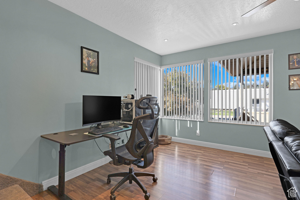 Office space with a textured ceiling and hardwood / wood-style flooring