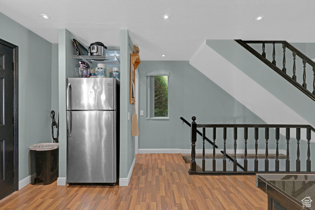 Kitchen with wood-type flooring and stainless steel fridge