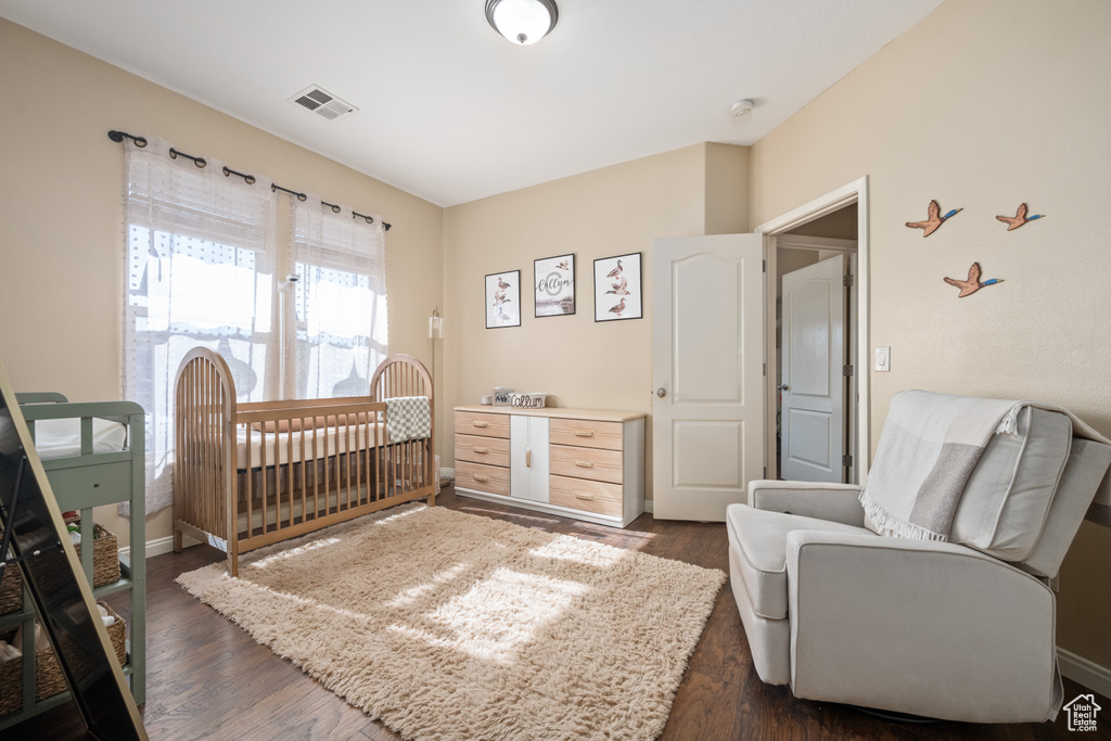 Bedroom with dark hardwood / wood-style flooring