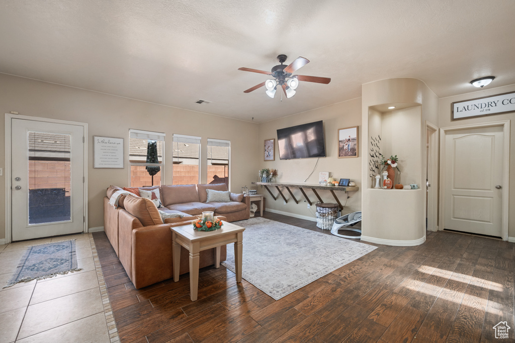 Living room featuring ceiling fan and dark hardwood / wood-style floors