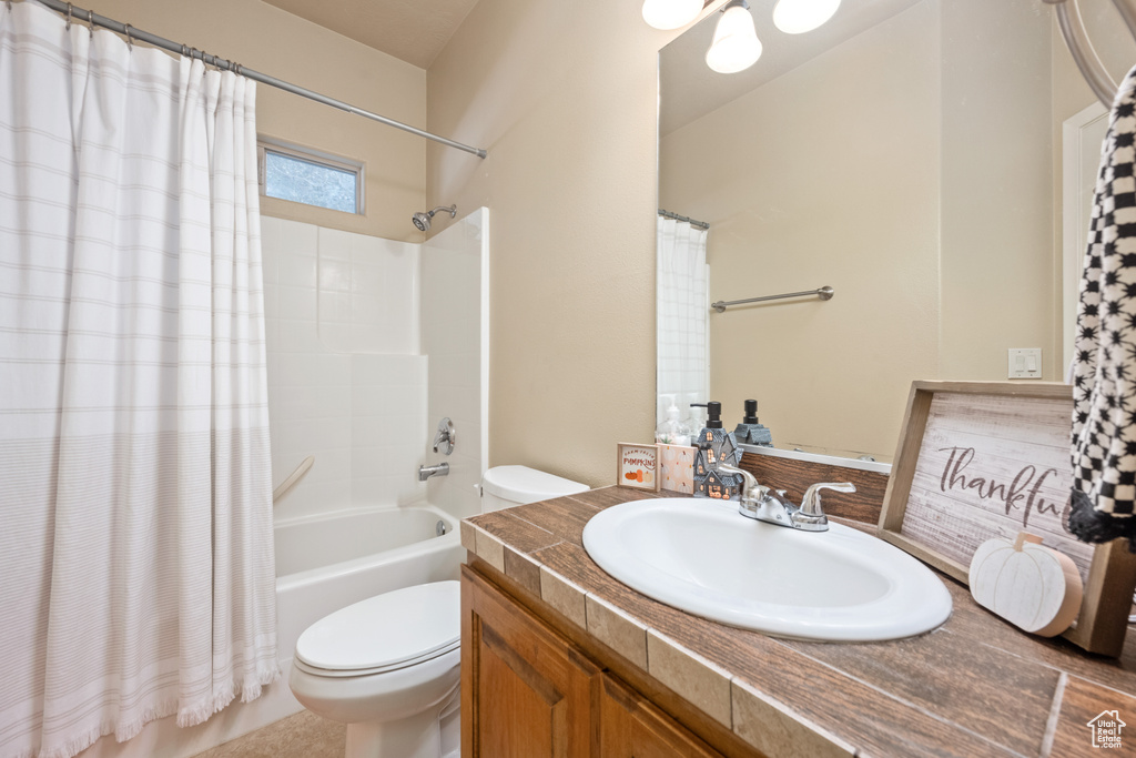 Full bathroom featuring shower / bath combo, vanity, and toilet