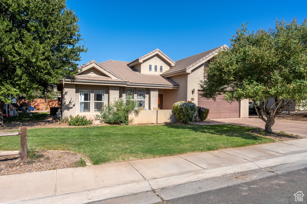 View of front of house featuring a garage and a front lawn