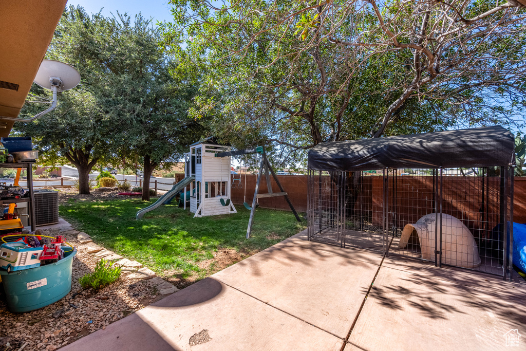 View of yard with a playground, central AC unit, and a patio area