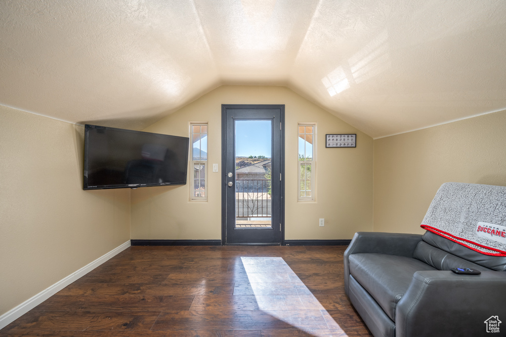 Interior space featuring vaulted ceiling, a textured ceiling, and dark hardwood / wood-style floors