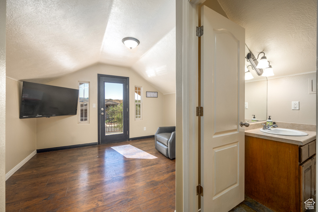 Bathroom with wood-type flooring, vaulted ceiling, a textured ceiling, and vanity