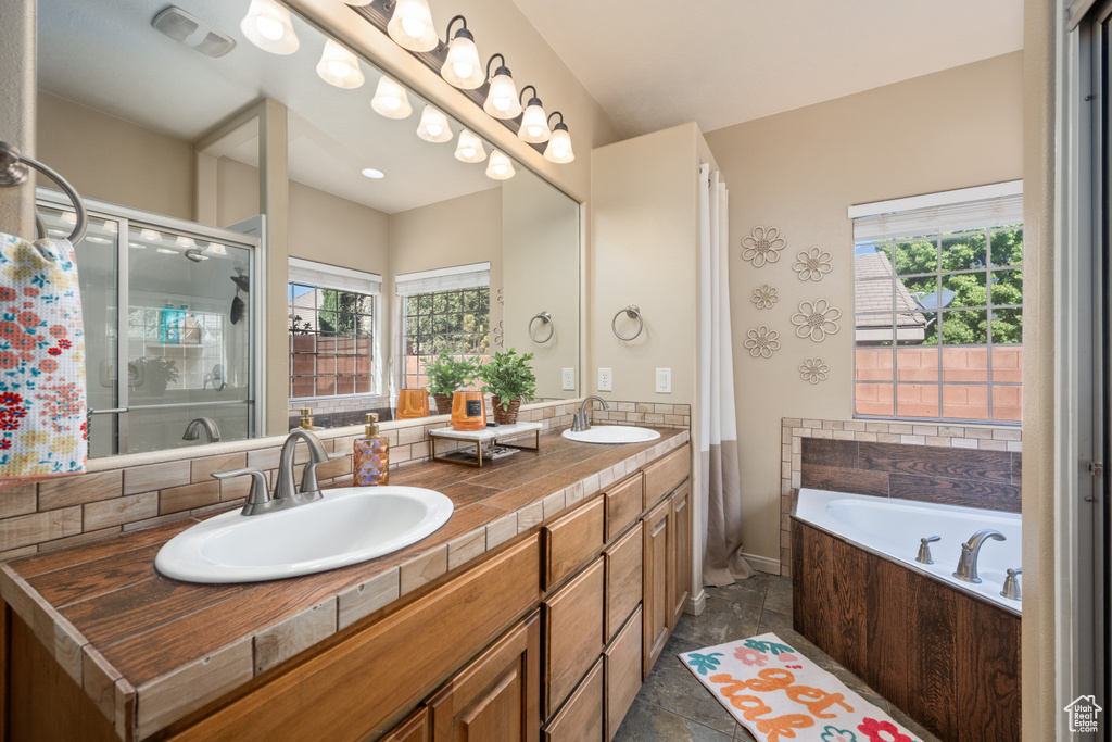 Bathroom with shower with separate bathtub, plenty of natural light, and vanity