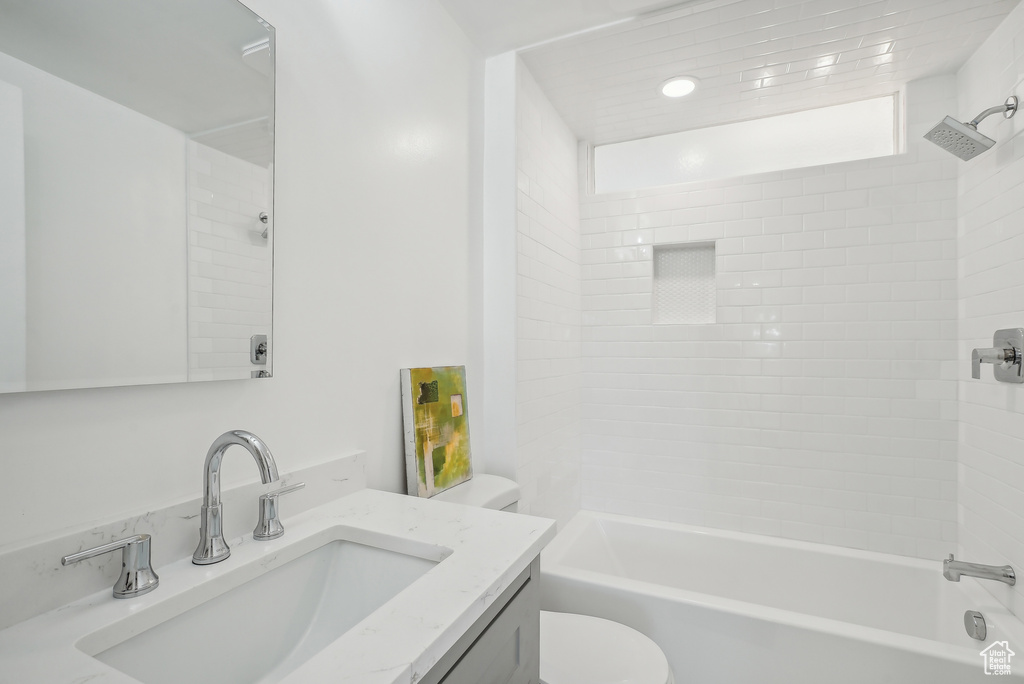 Full bathroom with vanity, toilet, and tiled shower / bath