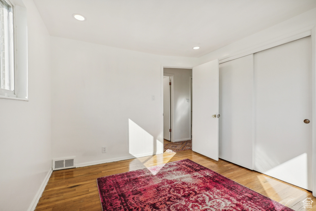 Bedroom featuring wood-type flooring, a closet, and multiple windows