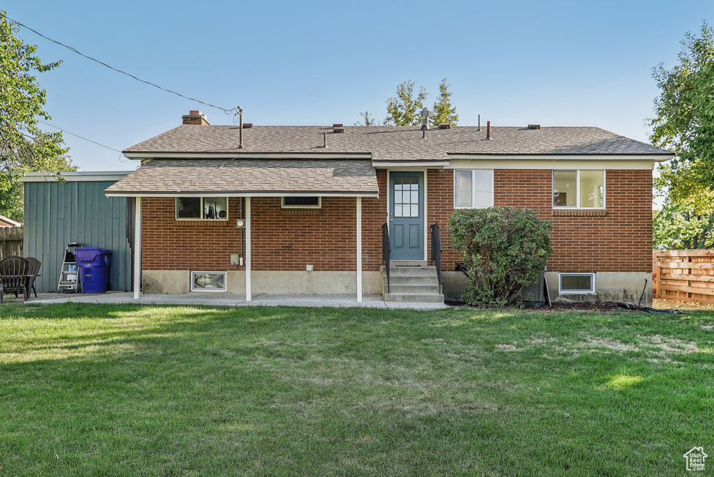 Back of property with a lawn