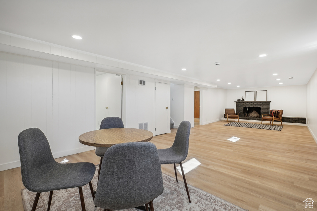 Dining space featuring light hardwood / wood-style flooring and a brick fireplace