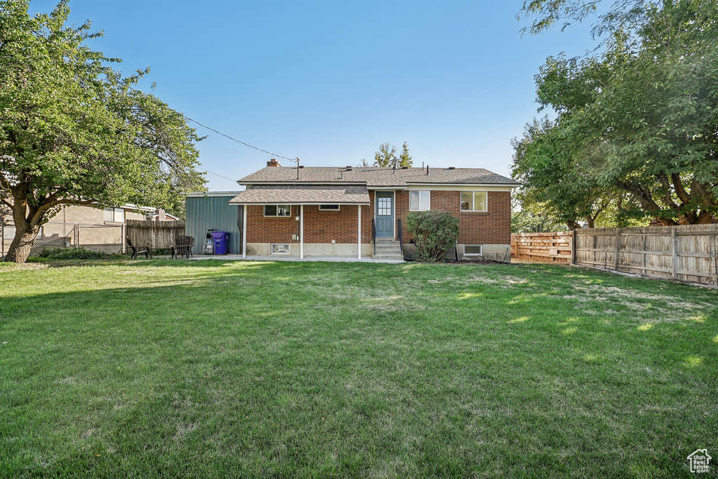 Rear view of house featuring a lawn