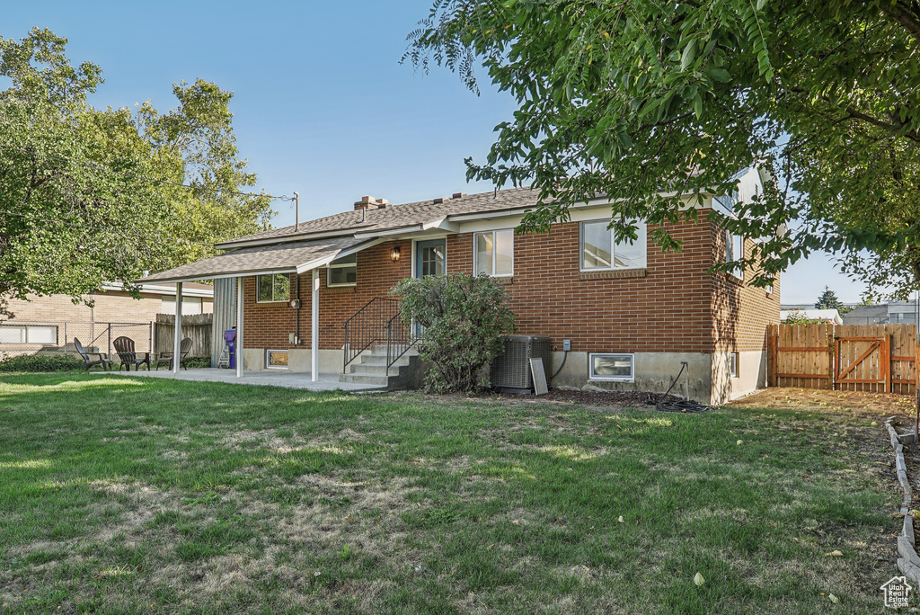 Back of property featuring a lawn, a patio, and central air condition unit