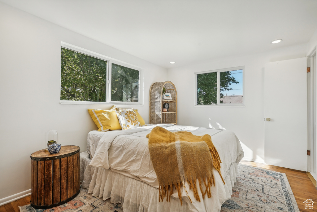 Bedroom with multiple windows and hardwood / wood-style floors