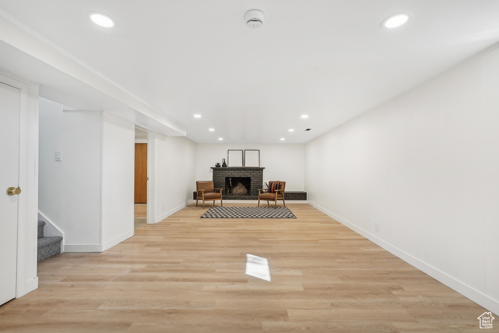 Interior space with light hardwood / wood-style flooring and a brick fireplace