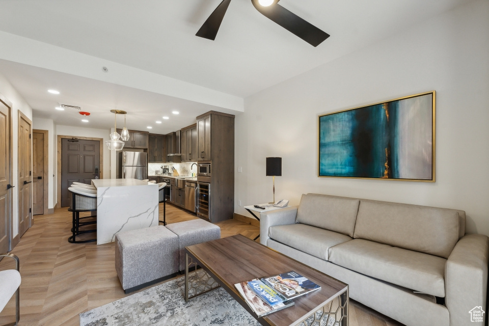 Living room featuring light parquet flooring and ceiling fan