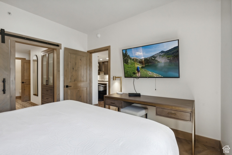 Bedroom featuring a barn door and connected bathroom