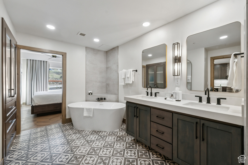 Bathroom featuring a bathing tub, vanity, and ceiling fan