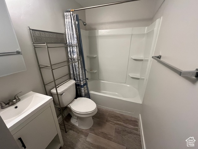 Full bathroom featuring shower / bath combo with shower curtain, vanity, and toilet