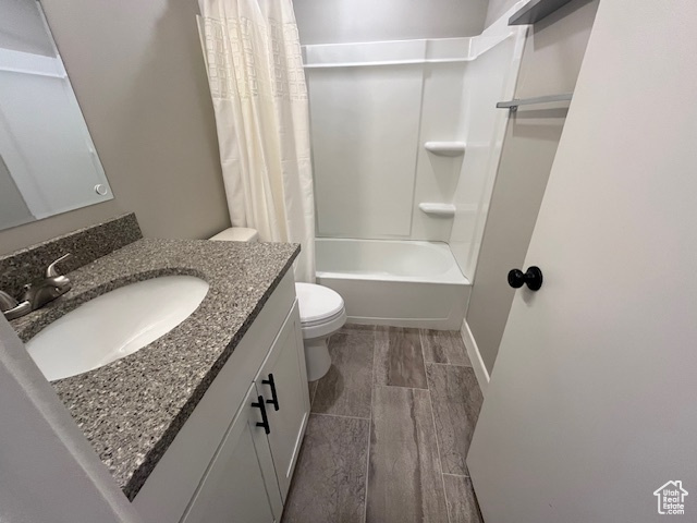 Full bathroom featuring shower / bath combo, vanity, toilet, and hardwood / wood-style flooring