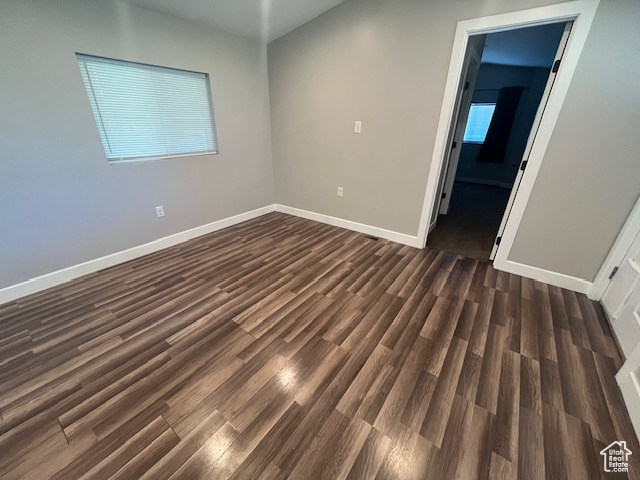 Empty room with dark hardwood / wood-style flooring