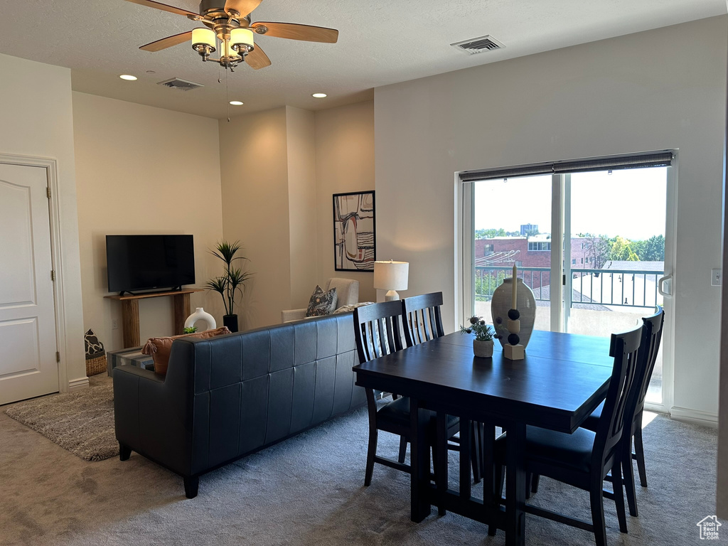 Dining space featuring a textured ceiling, carpet, and ceiling fan