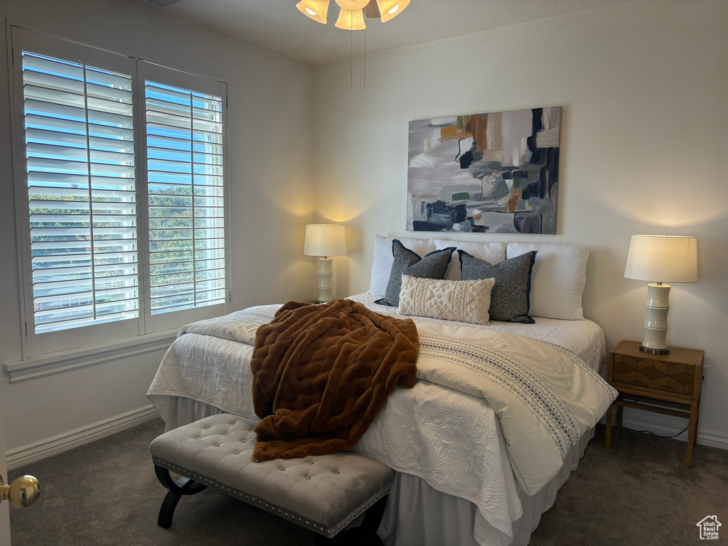 Bedroom featuring ceiling fan and dark colored carpet