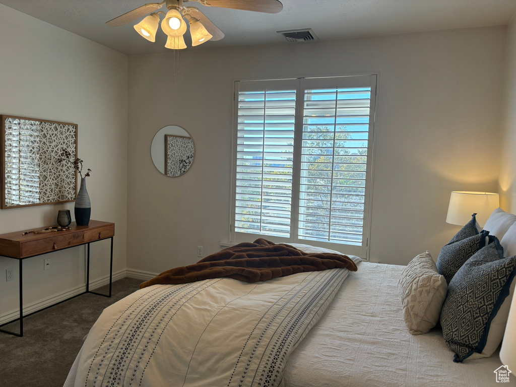 Carpeted bedroom featuring ceiling fan