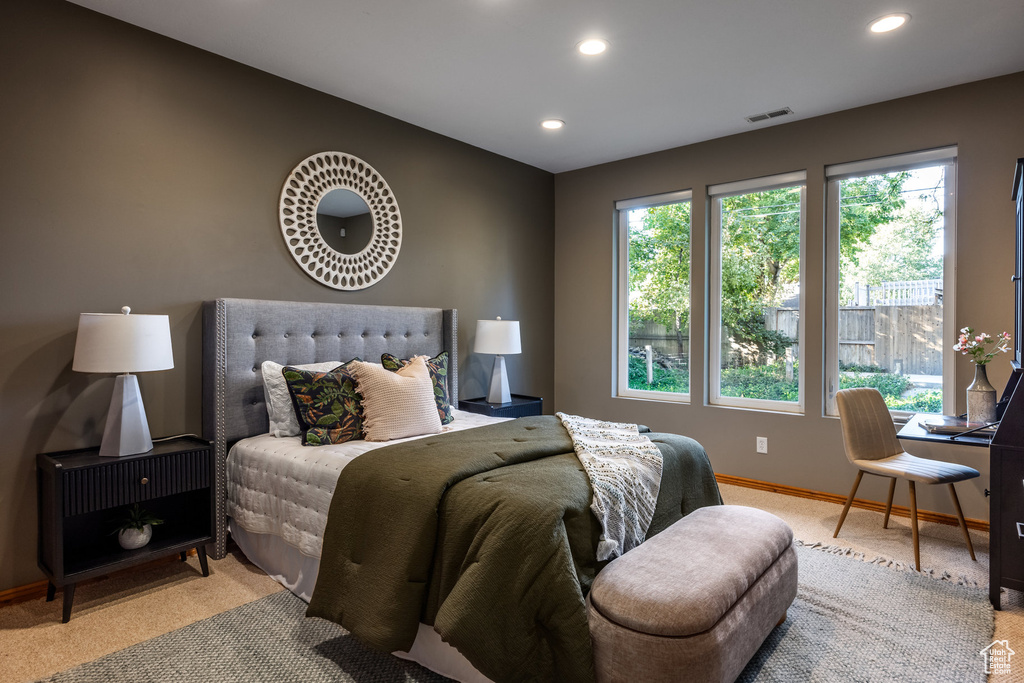 Carpeted bedroom featuring multiple windows