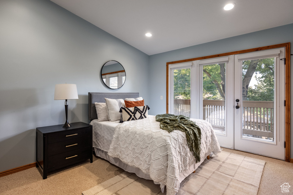 Carpeted bedroom with access to exterior and vaulted ceiling