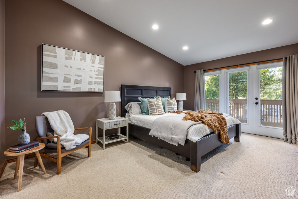 Bedroom featuring french doors, access to exterior, light colored carpet, and vaulted ceiling