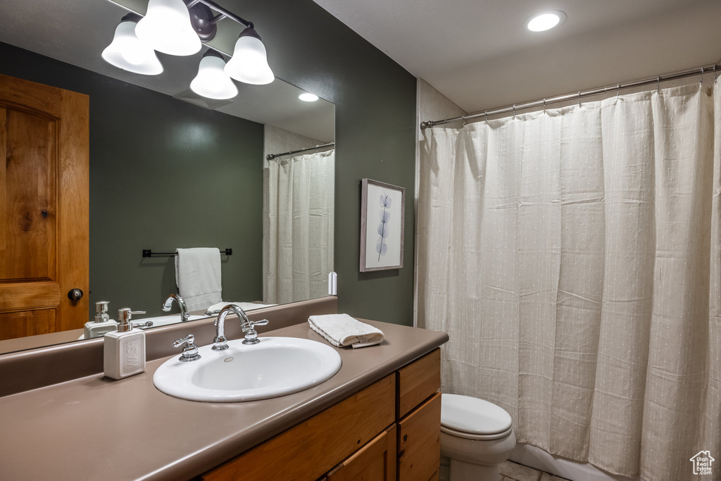 Bathroom featuring vanity, a shower with shower curtain, and toilet