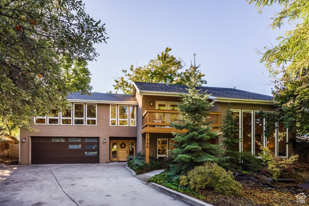 View of front of property with a garage and a balcony