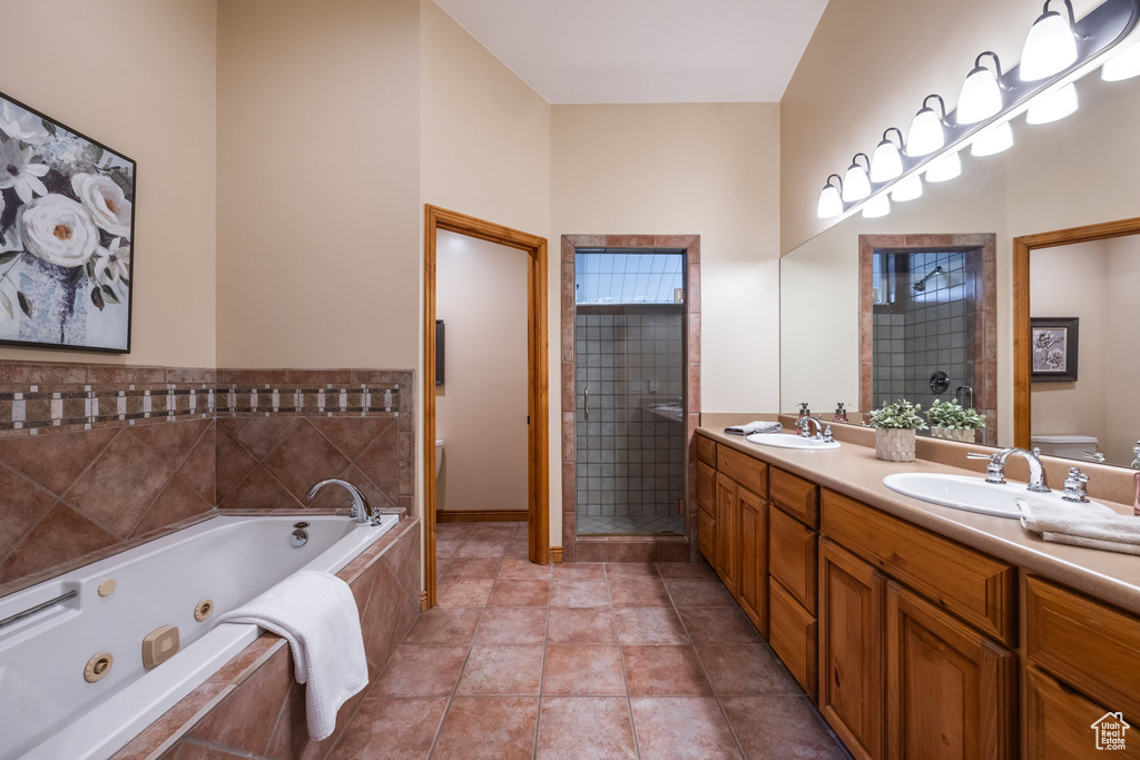 Full bathroom featuring vanity, independent shower and bath, toilet, and tile patterned floors