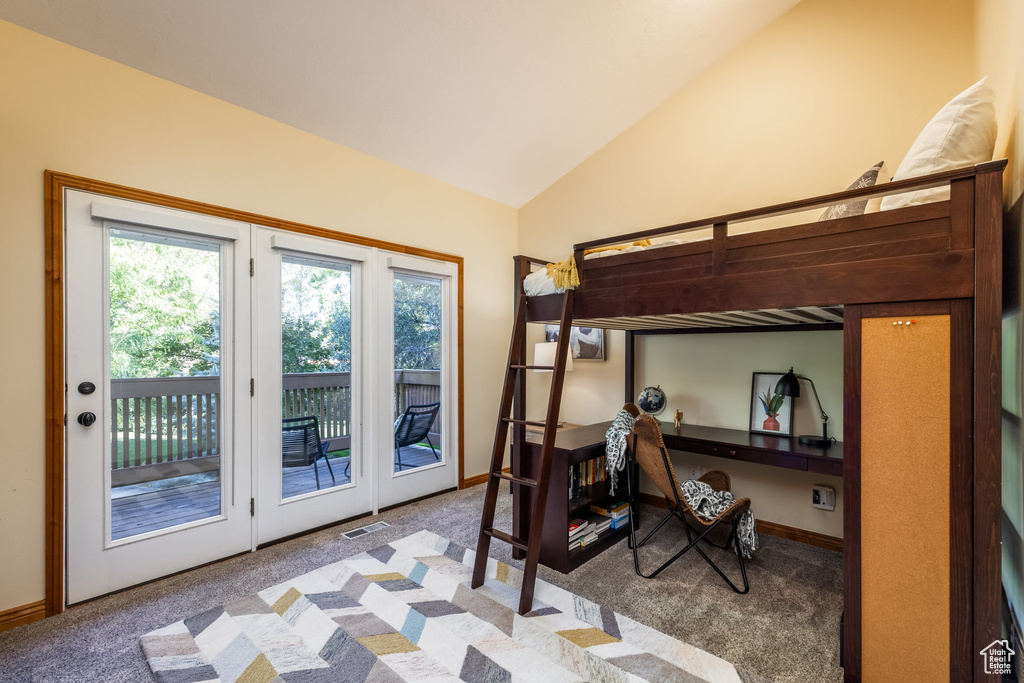 Carpeted bedroom with vaulted ceiling and access to exterior