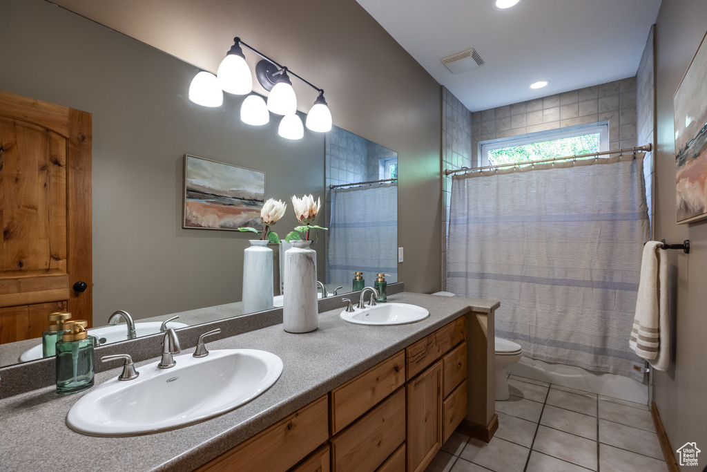 Full bathroom with toilet, vanity, shower / bath combination with curtain, and tile patterned floors