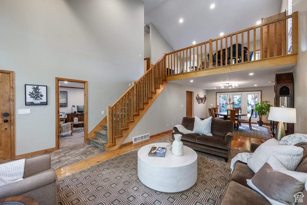 Living room featuring high vaulted ceiling and wood-type flooring