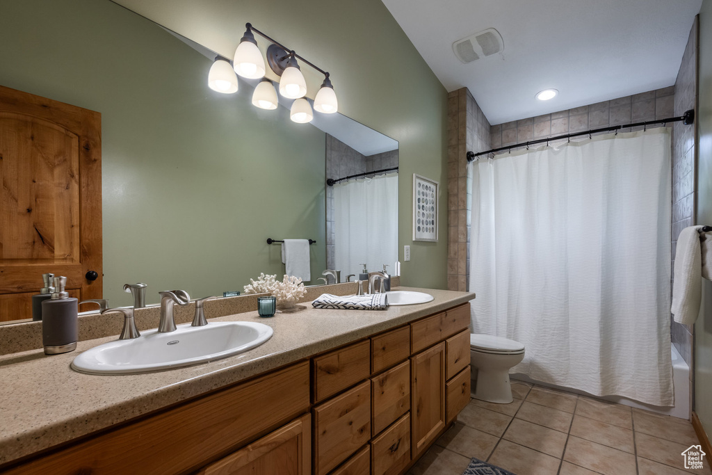 Full bathroom featuring toilet, shower / bath combo, vanity, and tile patterned floors