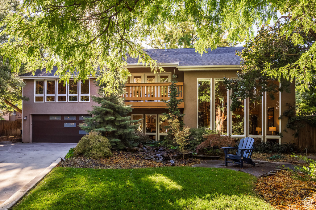 Back of property with a lawn and a garage