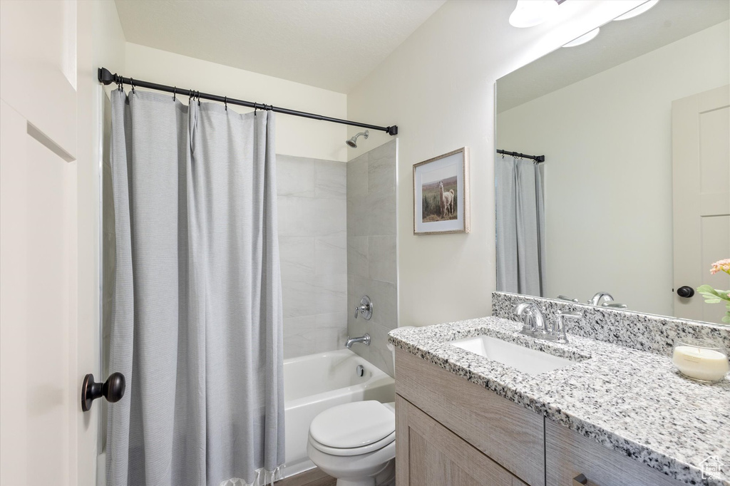 Full bathroom with shower / bath combo, vanity, and toilet