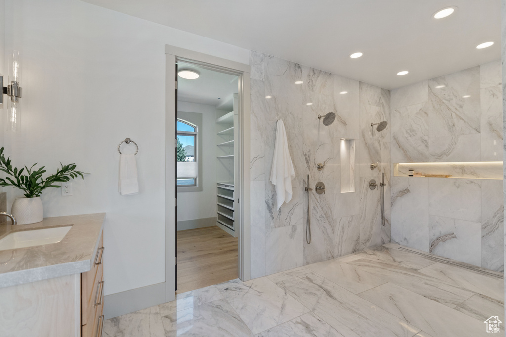 Bathroom with vanity and tiled shower