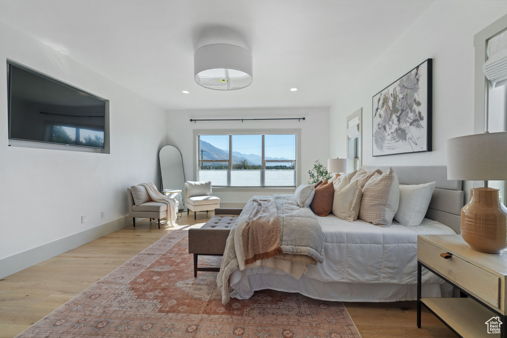 Bedroom with a water view and light hardwood / wood-style flooring