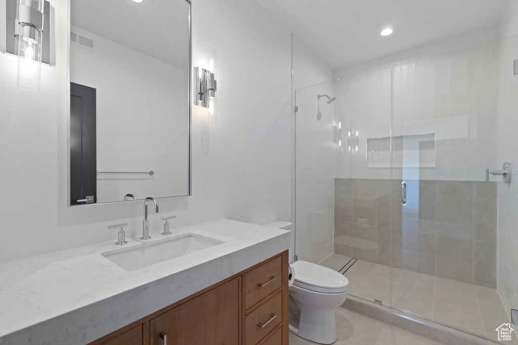 Bathroom featuring vanity, toilet, and a shower with shower door