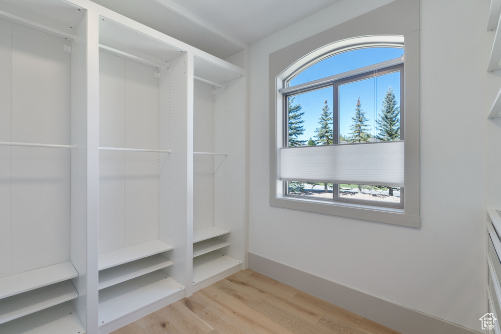 Spacious closet with light hardwood / wood-style floors