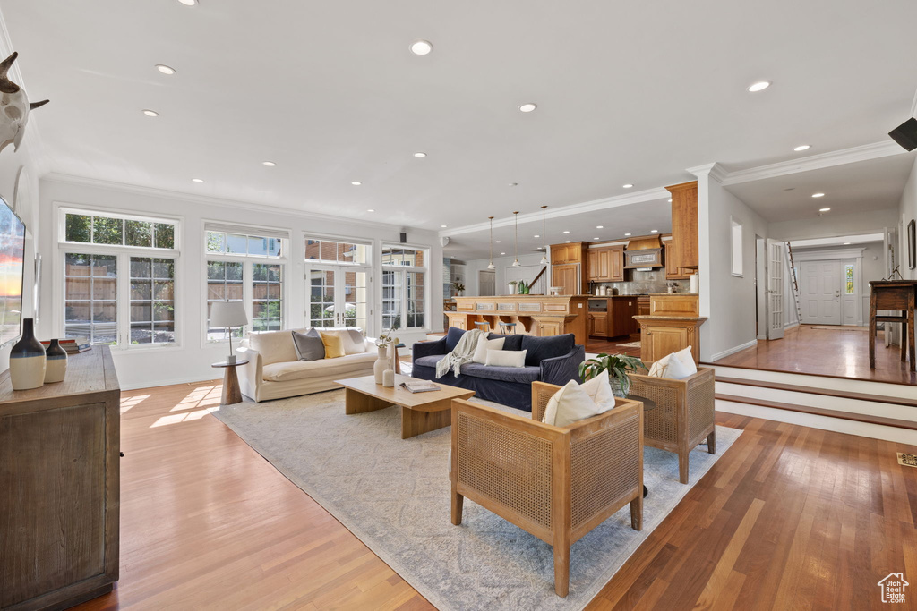 Living room with light wood-type flooring and ornamental molding