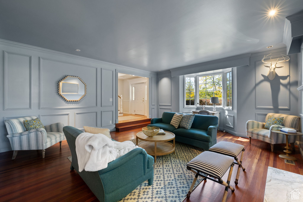 Living room with ornamental molding and dark hardwood / wood-style floors