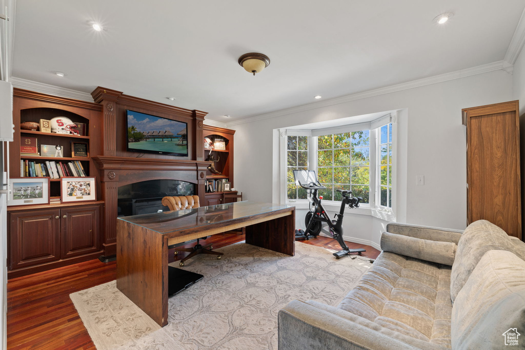 Home office with light wood-type flooring and crown molding